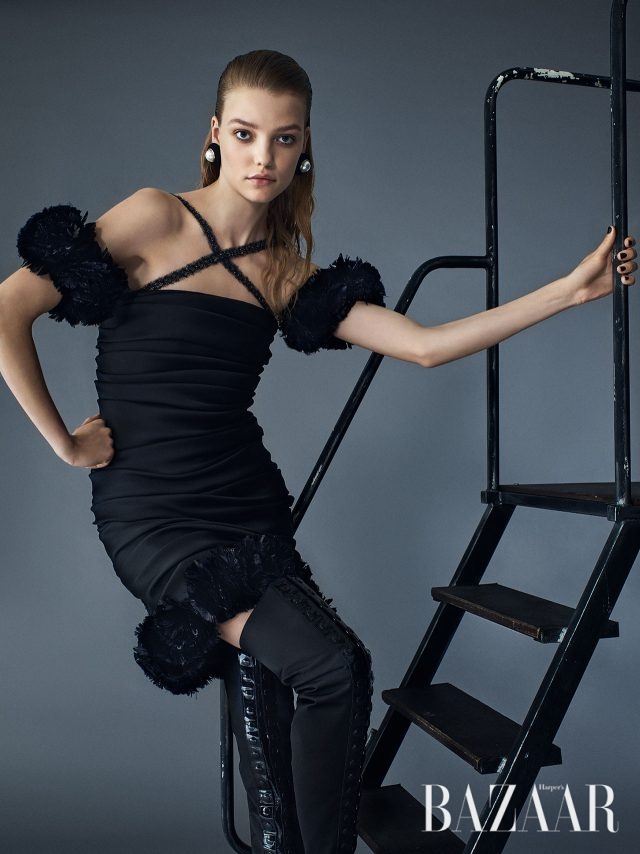 교차하는 스트랩 디테일이 매혹적인 리틀 블랙 드레스, 진주 귀고리, 버튼 장식의 사이하이 부츠는 모두 Chanel Haute Couture 제품.