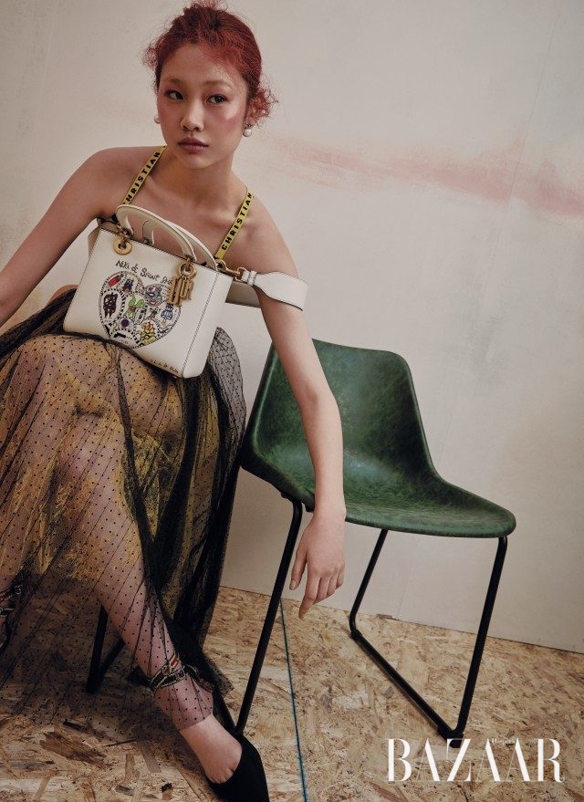 스트라이프 패턴의 보디수트,튤 스커트, 귀고리, 니키 드 생팔의 일러스트가 담긴 미스 디올 백, 플랫 슈즈는 모두 Dior 제품.